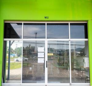 un bâtiment vert avec une porte coulissante en verre dans l'établissement Hatyai Humble Home 03, à Hat Yai