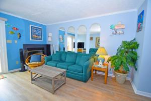 a living room with a blue couch and a table at Sea Jay Townhouse 616C in Ocean City
