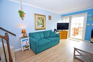 a living room with a blue couch and a television at Sea Jay Townhouse 616C in Ocean City