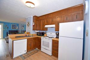 a kitchen with wooden cabinets and a white refrigerator at Sea Jay Townhouse 616C in Ocean City