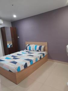 a bedroom with a bed with blue and white sheets at The Lodge- Bed and Breakfast Hotel in Trivandrum