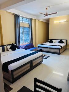 Gogāmukh的住宿－HOTEL CKD，酒店客房,设有两张床和一张沙发