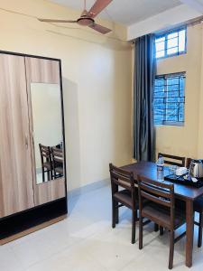 Gogāmukh的住宿－HOTEL CKD，一间带桌椅和镜子的用餐室