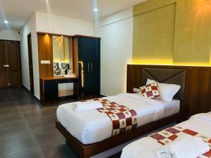 Meenangadi的住宿－Mary Land Residency，一间酒店客房,房间内设有两张床