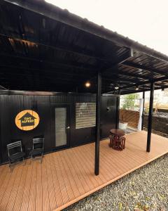 a covered deck with two chairs and a table at Cozy Tiny Home with Outdoor Hot Tub in City Center in Davao City