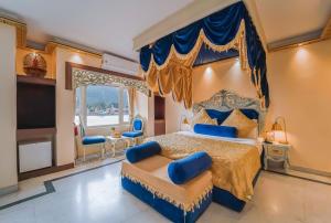 um quarto com uma cama king-size e um dossel azul em The Neeraj Ganga Heritage Palace em Rishikesh