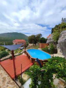a swimming pool on a deck next to a house at Old House Lapis- pool, hot tub, BBQ in Zadvarje