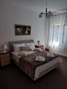 a bedroom with a large bed with two towels on it at Old House Lapis- pool, hot tub, BBQ in Zadvarje +20 photos