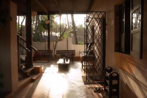 a hallway of a house with a light shining through the door at The Wild Flower! in Anjuna