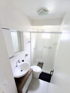 Baño blanco con lavabo y aseo en Apto 1 quarto em BC, vista mar, ar condicionado split no quarto e na sala, en Balneário Camboriú