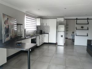a kitchen with a refrigerator and a table in it at 394OnEmus in Pretoria