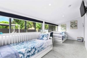 Un dormitorio con una cama y una ventana grande. en Pet Friendly Beach House with pool - Sleeps 10, en Urangan 18 fotos más
