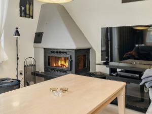 a living room with a fireplace and a table at 6 person holiday home in R dby in Rødby