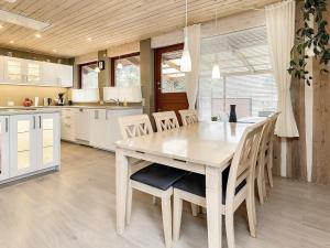 a kitchen with a wooden table and chairs at 6 person holiday home in R dby in Rødby