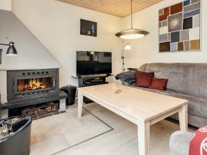a living room with a couch and a fireplace at 6 person holiday home in R dby in Rødby