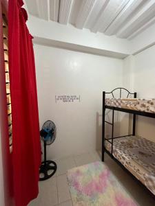 Habitación con 2 literas y ventilador. en Caishen Modern Affordable Apartelle 302, en Silang