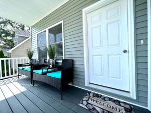 a porch with a white door and a table and chairs at Beach House Cape May just 1 block from the Bay & a Short 5 minutes walk, Sleeps 19 in Cape May