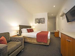 a hotel room with a bed and a couch at Comfort Inn & Suites Sombrero in Adelaide