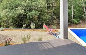 a red chair sitting on a patio next to a pool at La Maison Des Adrets in Vins-sur-Caramy