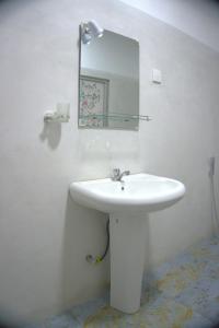 a bathroom with a white sink and a mirror at Golden Holiday Home in Arambegama