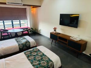 a hotel room with two beds and a flat screen tv at Mary Land Residency in Meenangadi