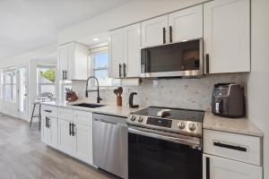a kitchen with white cabinets and a black stove top oven at Tranquil Pet Friendly Retreat residence in Reynoldsburg