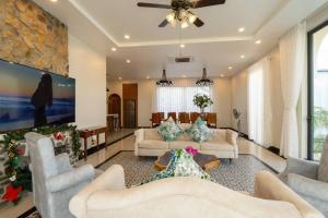 ein Wohnzimmer mit 2 Sofas und einem TV in der Unterkunft Amanda villa 4 Phan Thiết in Mui Ne