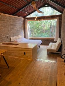 Camotepec的住宿－Cabaña en el bosque，一间卧室设有一张床和一个大窗户