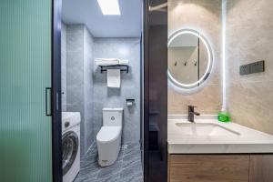 uma casa de banho com um lavatório, um WC e um espelho. em Yozo Serviced Apartment em Xangai