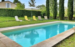 una piscina con tumbonas y sombrilla en La Fleur Godard, en Lussac