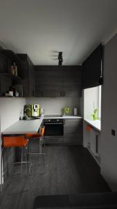 a kitchen with black and white cabinets and a counter at Mucenieku Apartamenti in Kuldīga
