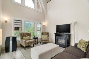 sala de estar con sofá y chimenea en Modern 4BR Penthouse w/Lake Views & Rooftop Deck, en Harrison Hot Springs