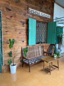 a wooden wall with a bench and a table at Cọ Cùn homestay/Handmade/Artwork in Buon Ma Thuot