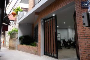 un accès à un bâtiment en briques avec une porte ouverte dans l'établissement JOY APARTMENT TAY HO, à Hanoï