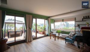 uma sala de estar com janelas grandes e um sofá em JOY APARTMENT TAY HO em Hanói