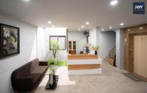 - un hall avec un canapé et un escalier fleuri dans l'établissement JOY APARTMENT TAY HO, à Hanoï