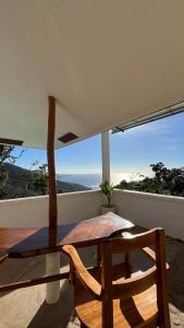 una mesa de madera y una silla en un balcón con vistas en Casa Leonardo, en Bacungan