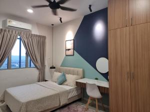 a bedroom with a bed and a desk and a ceiling fan at ZIYAD AL KHAYR HOMESTAY in Kajang