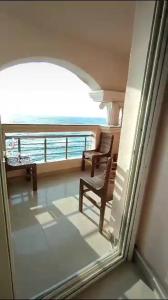 a balcony with two chairs and a view of the ocean at شقه فندقيه بالإسكندرية in Alexandria