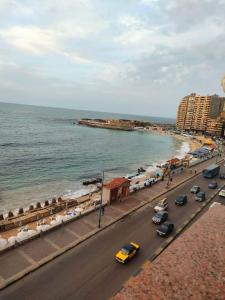 a busy city street with cars parked on the beach at شقه فندقيه بالإسكندرية in Alexandria