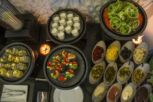 einen Tisch mit Schalen verschiedener Arten von Lebensmitteln in der Unterkunft The Wander by Sarai in Siem Reap