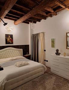 a bedroom with a bed and a dresser in a room at Centro storico, centralissimo LUXURY SMERALDO SUITE doccia idromassaggio , paniere gratuito con piccola colazione in Ravenna