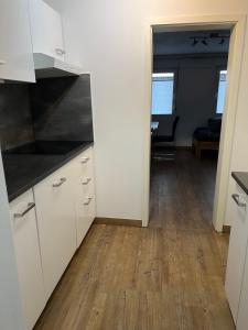a kitchen with white cabinets and a wooden floor at Ferienwohnung Eport in Bendorf