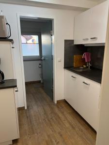 una cucina con mobili bianchi e una finestra di Ferienwohnung Eport a Bendorf