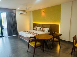 Mary Land Residency في Meenangadi: غرفة نوم بسرير وطاولة وكراسي