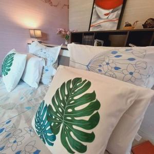a bedroom with two beds with white sheets with a leaf pattern at Le Zen in La Ciotat