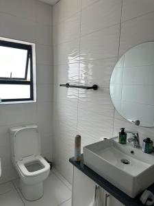 a white bathroom with a toilet and a sink at STUNNING VACATION HOME in Hentiesbaai