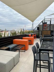 a rooftop patio with tables and chairs on a building at ALT URBANA in León