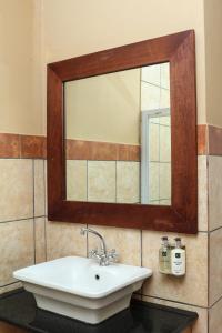 a bathroom with a sink and a mirror at Thaba Legae Guest Lodge in Rustenburg