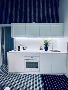 ポルトヴェーネレにあるAbout Italy Holiday Rooms and Apartmentsの白いキャビネットとシンクのあるキッチン